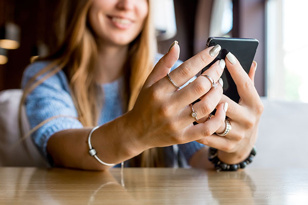 smiling woman looking at her cell phone